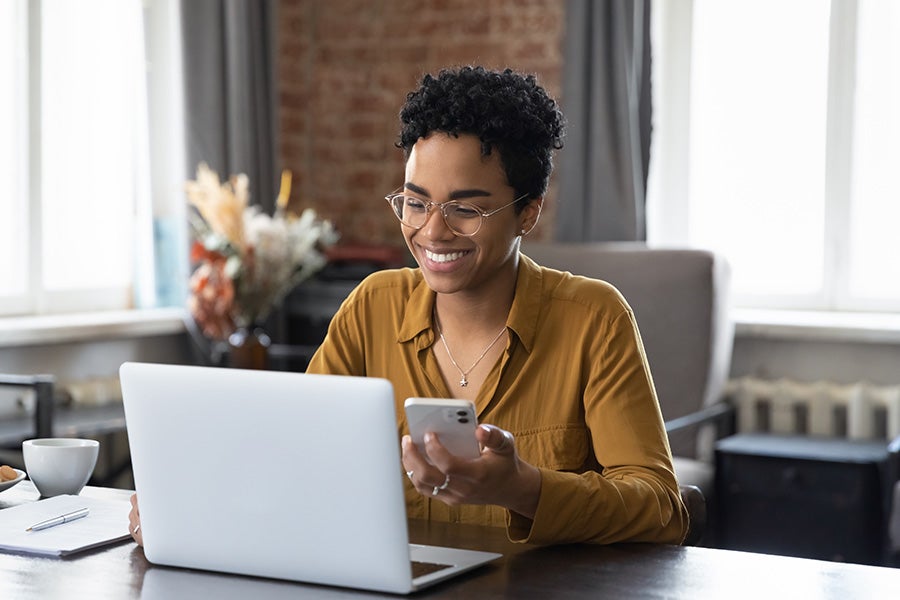 New employee smiling while looking on laptop screen