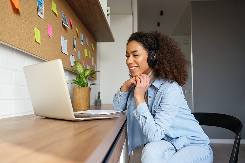 woman smiling while looking to computer screen